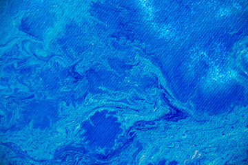 Fototapeta na wymiar Blue acrylic ink in liquid, close up view. Abstract background. Paint dissolving into water. Abstract blue clouds swirling in water. Acrylic waves in liquid, abstract pattern. Blurred background