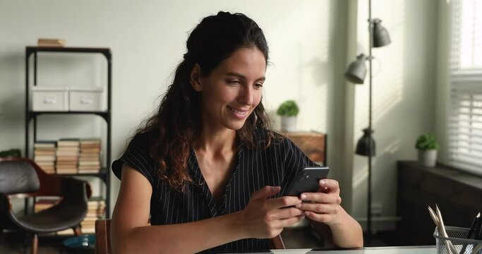 35s woman sit indoor hold smartphone distracted from work spend time in social media network, learn new mobile app, choose goods in retail services ecommerce web store, modern tech usage, fun concept