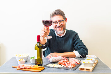 Mature man, drink a toast with red wine, during appetiz