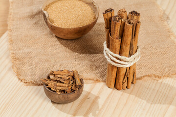 cinnamon stick and brown sugar; photo on wooden background.