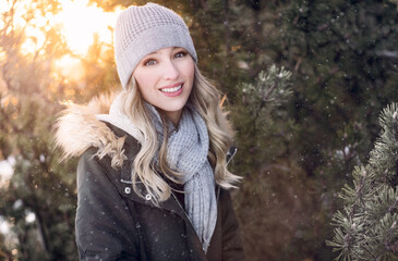 A beautiful young woman smiling in a wintry setting with warm clothes