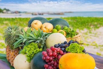 Fresh Fruits on the beach. Assorted tropical fruits, papaya, grape, watermelon, pineapple, trolley and lemon.