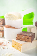 Healthy fit and sport background. Slimming concept. Variety of flavors of protein cocktail powder, ready-made cocktail in bottle and bars on white background.