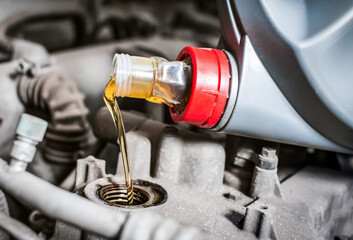 Pouring new engine oil into the car engine. Close-up