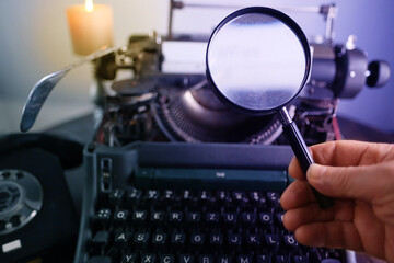 old typewriter on table, words true story are printed on paper in large size, retro style, magnifying glass, concept of writer, journalist, private detective