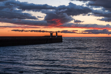 The North Pier Lighthouse with some dark clouds after sunset in Whitehaven, Cumbria, England, UK