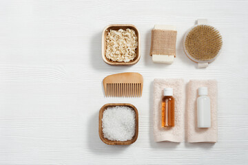 Fototapeta na wymiar Flat lay composition with bath accessories with small bottles with gel and shampoo, soap, sea salt, washcloth