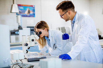 Group of young researchers analyzing chemical data in the laboratory