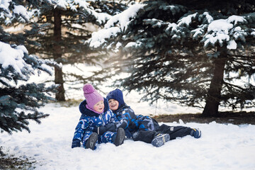 Fototapeta na wymiar Boy and girl playing and laughing in winter forrest
