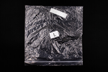 Plastic packaging bag with L size marking, texture transparent stretched film polyethylene on black...