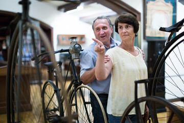 mature couple turists examines the exhibit in museum