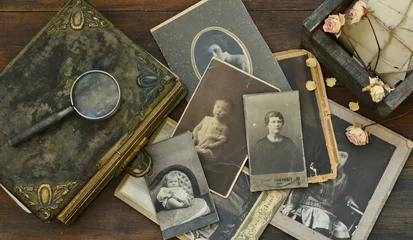 Fotobehang  Still-life with old photo album and historical photos of family © Irina
