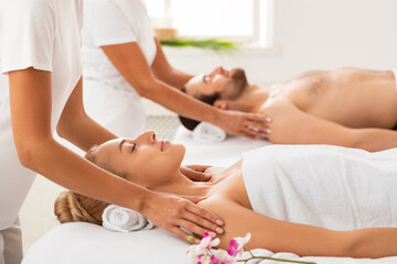 Fototapeta na wymiar Spouses Receiving Shoulders Massage Relaxing At Luxury Spa Center