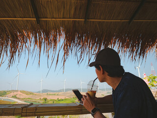 solo traveler man sit and drink coffee at counter bar with wind turbine background