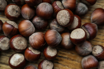 Top view Hazelnuts in nutshell, cracked nuts, wooden background.
