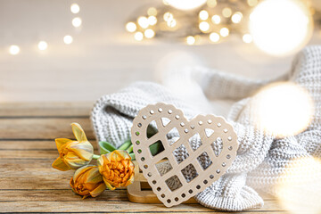 Cozy home composition for Valentine's Day with a decorative heart and flowers.