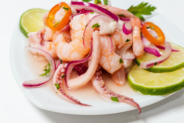 Typical Peruvian food, squid ceviche, shrimp and white fish with purple onion and a good tiger milk. Side view.