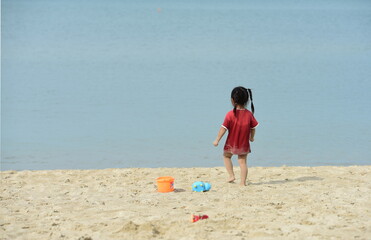 Children are having fun at the beach on a beautiful day, the sky is clear.