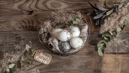 Easter composition with decorative eggs in a basket on a wooden surface.