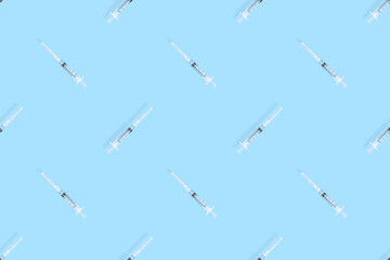 Medical syringes seamless pattern. Medical syringes on a blue background.