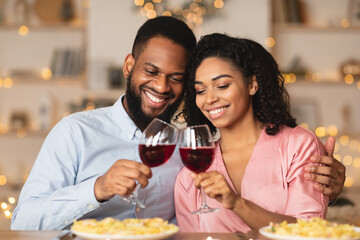 Smiling black woman and man drinking wine on a date