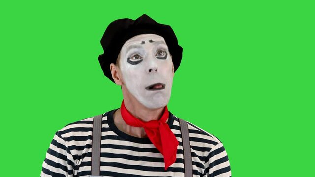 Mime artist holding imaginary balloons and flying on a Green Screen, Chroma Key.