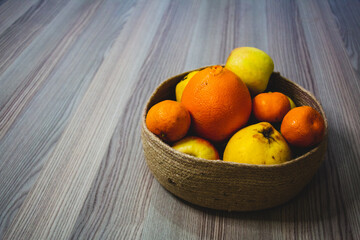 Fruits standing in a basket. Orange, quince, tangerine.