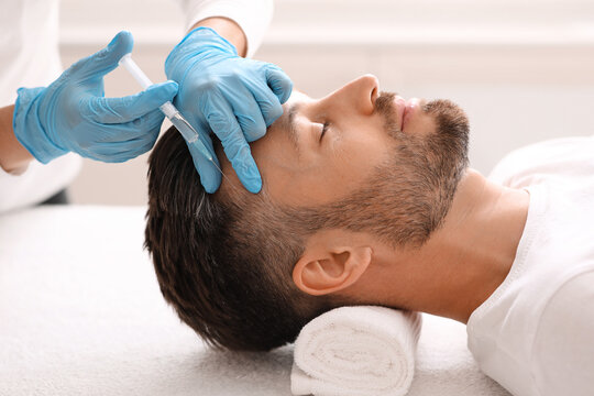 Middle-aged man having hair treatment at beauty salon