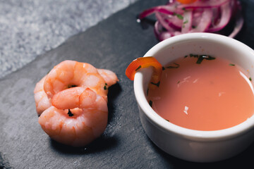 Peruvian Ceviche served in a signature cuisine. Close-up of shrimp and tiger milk in a bowl.