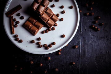 Chocolate - Mesa de doces com barras de chocolate, pedaços de canela, deliciosa cobertura de leite doce com bolas de chocolate.