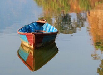 wooden boat on the lake, reflection of the bat in the lake,fishing boat in a calm lake water.