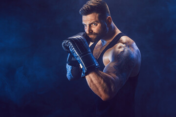 Sportsman boxer fighting on black background with shadow. Copy Space. Boxing sport concept. Smoke on background