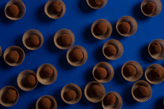 Many chocolate truffles on blue background