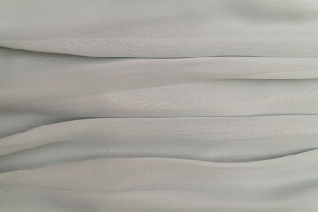 the texture of the fabric in folds of gray pastel color, the background of a luxurious delicate fabric