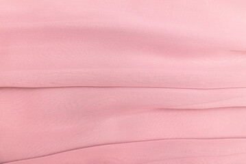 the texture of the fabric in the folds of pink pastel color, the background of a luxurious delicate...