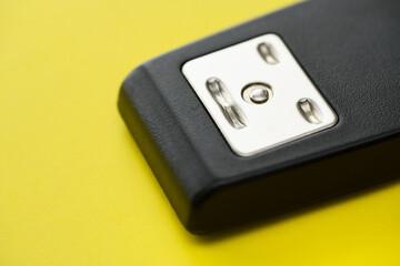 White face on a black stapler on yellow background