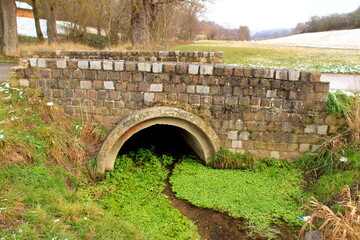 Brücke über den Strudelbach bei Weissach. Der Durchlass ist mit Pflanzen leicht verstopft