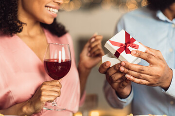 Young black man giving box with jewelry to his girlfriend