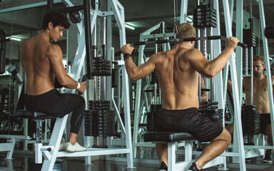 Muscular men doing exercise in gym