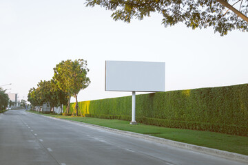 Advertising billboard mockup image with white screen posters at street park with trees. Copy space for text.