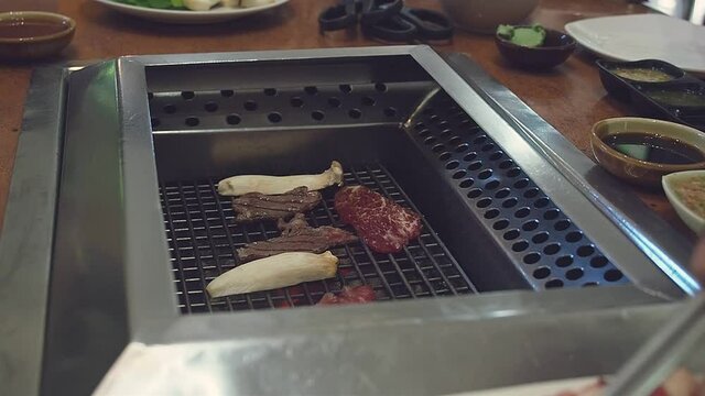 Juicy Wagyu A5 beef sliced and mushroom grilling on Japanese yakiniku stove. Japanese food.