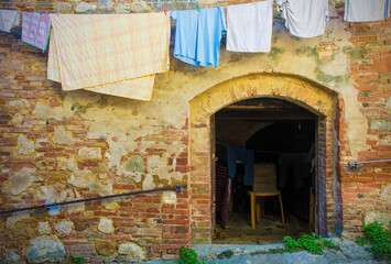 An open doorway with washing hanging outside in the historic medieval town of Montepulciano in Siena Province, Tuscany, Italy
