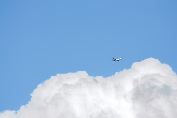 the plane flies in the cloudy sky