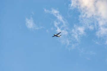 the plane flies in the cloudy sky