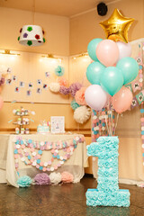 Birthday party for child one years old. Pink, mint and white colors. Stylish Birthday decorations and big number one