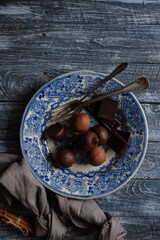 chocolate candies in a vintage blue plate on a wooden background