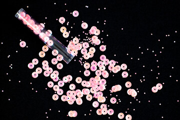 Sequins tube scattered on black background close up © Kostrikina