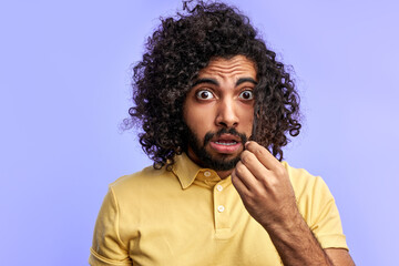 male in shock, look at camera touching long curly hair, isolated in studio