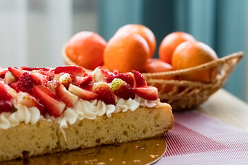 Berry pie on the holiday table with tangerines in the background. delicious pie with cream and fresh strawberry slices