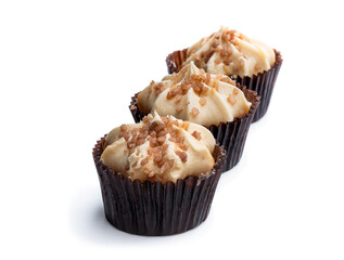 Mini sponge cakes with caramel buttercream topped isolated on white